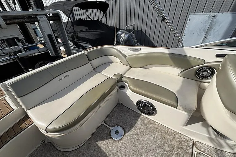 Slide: The Image of 2005 Sea Ray 240 Sundeck interior with beige seating and speaker system. - 7