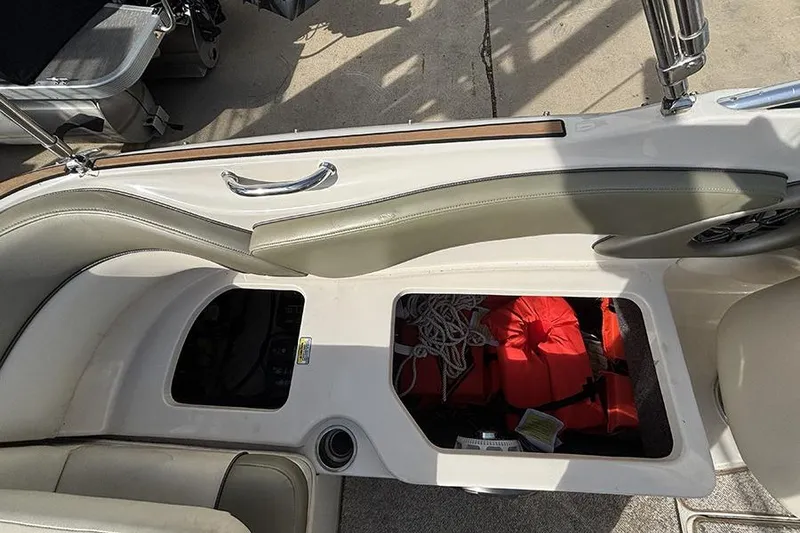 Slide: The Image of 2005 Sea Ray 240 Sundeck interior storage with life jackets and ropes visible. - 8