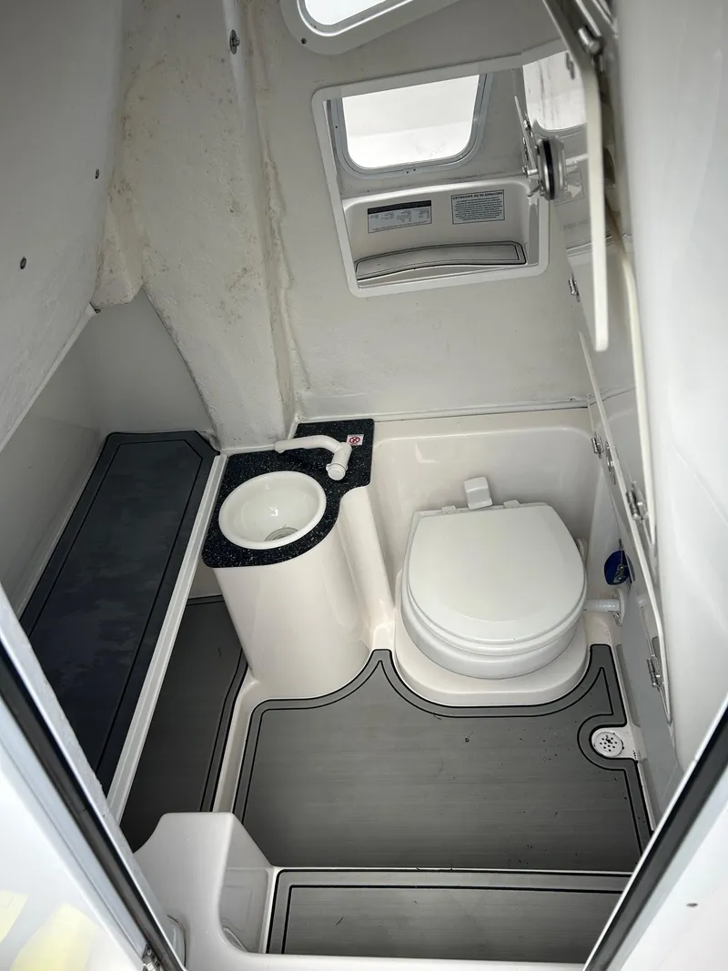 Slide: The Image of 2022 Sea Fox 268 Commander boat bathroom with toilet, sink, and window. - 11