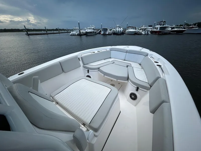 Slide: The Image of 2022 Sea Fox 268 Commander boat interior with cushioned seating, docked at marina. - 7