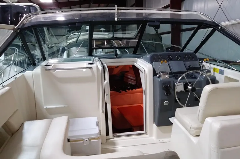 Slide: The Image of 1993 Tiara 3100 Open boat interior with helm, seating, and cabin entrance. - 13