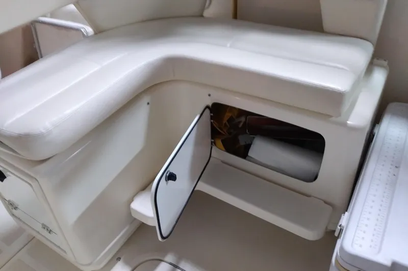 Slide: The Image of 1993 Tiara 3100 Open boat interior with white cushioned seating and storage compartment. - 15