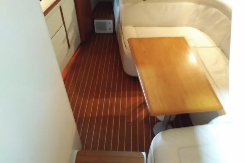 Slide: The Image of Interior of 1993 Tiara 3100 Open yacht with wooden table and white seating. - 23