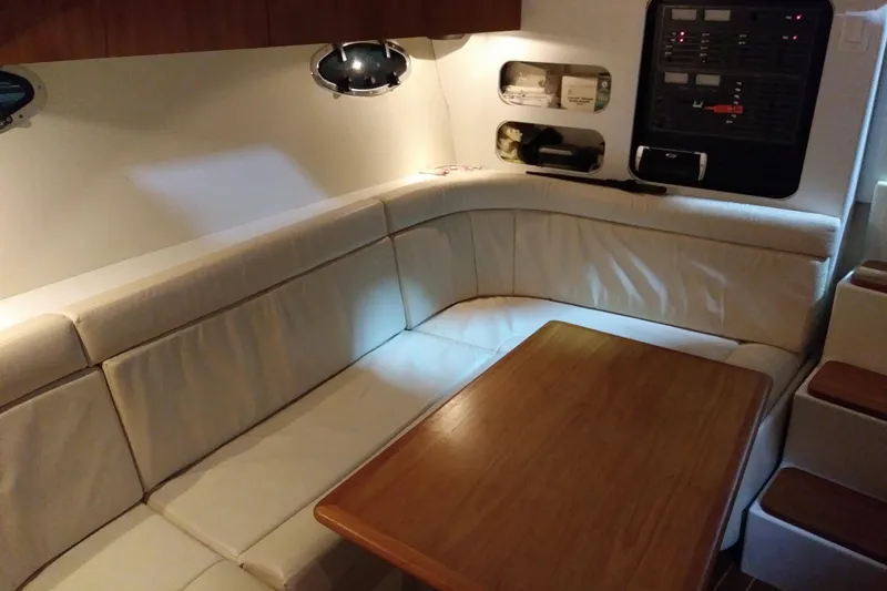 Slide: The Image of Interior of 1993 Tiara 3100 Open yacht with white seating and wooden table. - 28