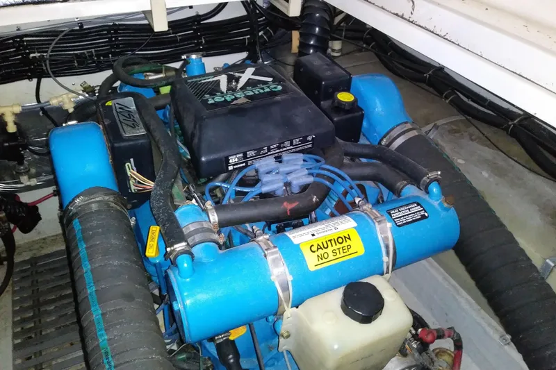 Slide: The Image of Engine compartment of a 1993 Tiara 3100 Open boat, featuring a blue marine engine. - 31