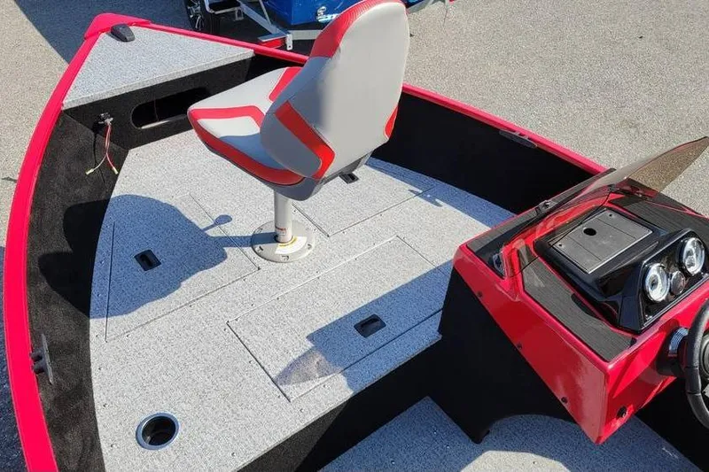 Slide: The Image of 2026 Smoker Craft Lazer 161 boat interior with red and gray seating and dashboard. - 4