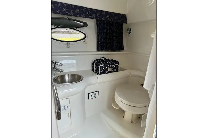 Slide: The Image of 2002 Formula 330 Sun Sport boat bathroom with sink, toilet, and porthole window. - 17