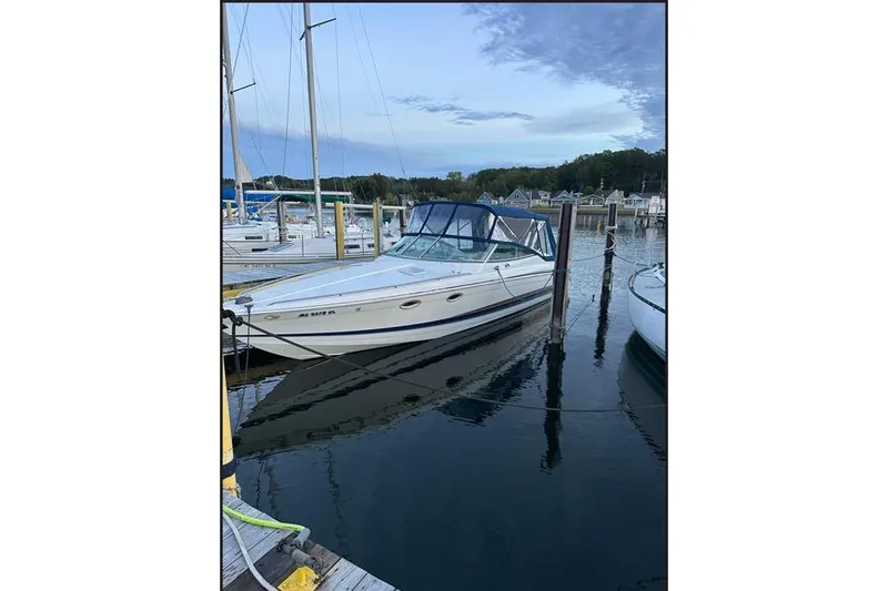 Slide: The Image of 2002 Formula 330 Sun Sport boat docked in a marina, calm water reflection. - 2