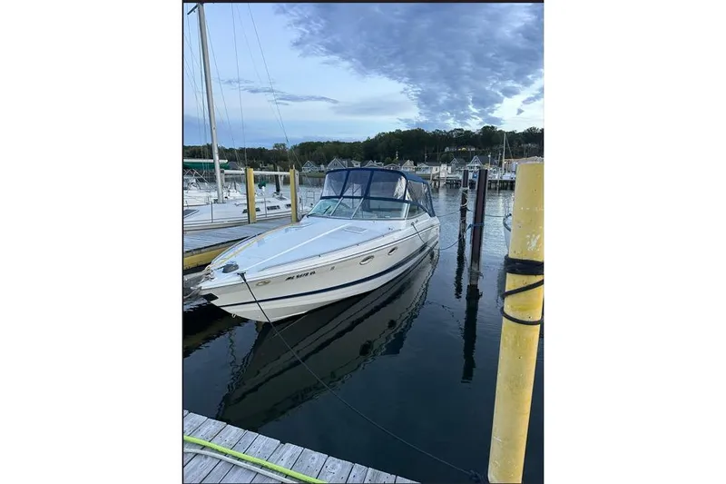 Slide: The Image of 2002 Formula 330 Sun Sport boat docked at marina under cloudy sky. - 4