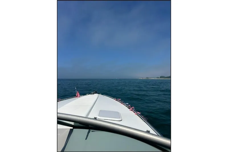 Slide: The Image of 2002 Formula 330 Sun Sport boat cruising on open water under clear blue sky. - 9