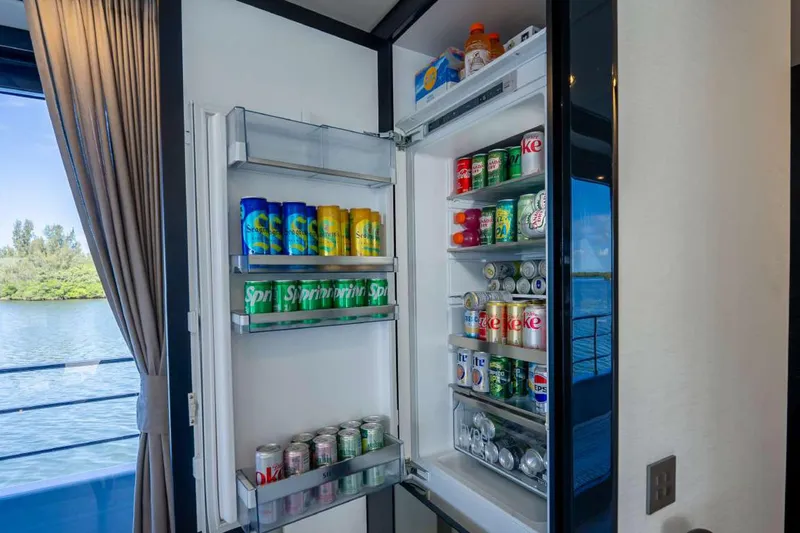 Slide: The Image of Open fridge on Sunreef Supreme 68 Power yacht, stocked with beverages, overlooking water view. - 31