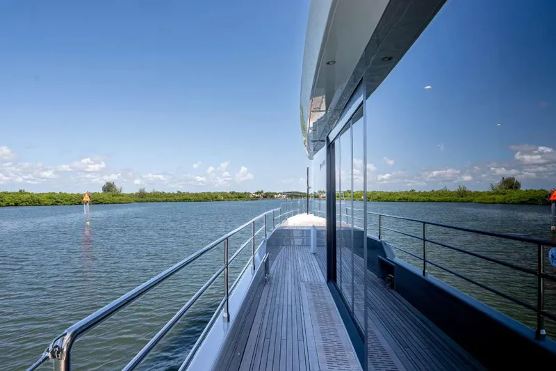 Slide: The Image of 2021 Sunreef Supreme 68 Power yacht on serene waterway, clear skies, lush greenery. - 44