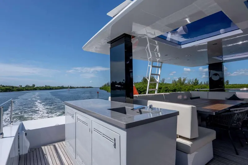 Slide: The Image of Luxurious Sunreef Supreme 68 Power yacht deck with seating, bar, and scenic waterway view. - 50