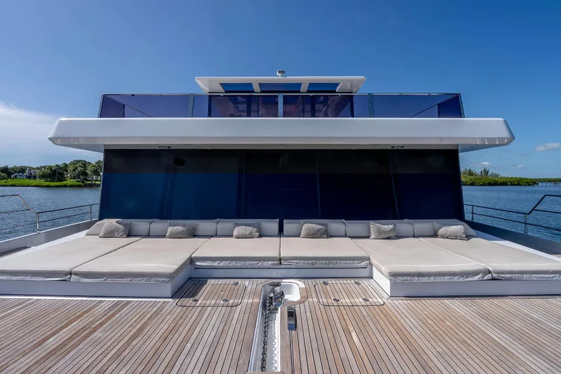 Slide: The Image of Luxurious Sunreef Supreme 68 Power yacht deck with sunbeds, 2021 model, on a serene waterway. - 57