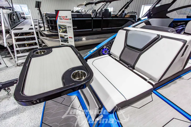 Slide: The Image of 2023 Yamaha Boats 255XE interior with seating and table, showcased in a marina setting. - 10