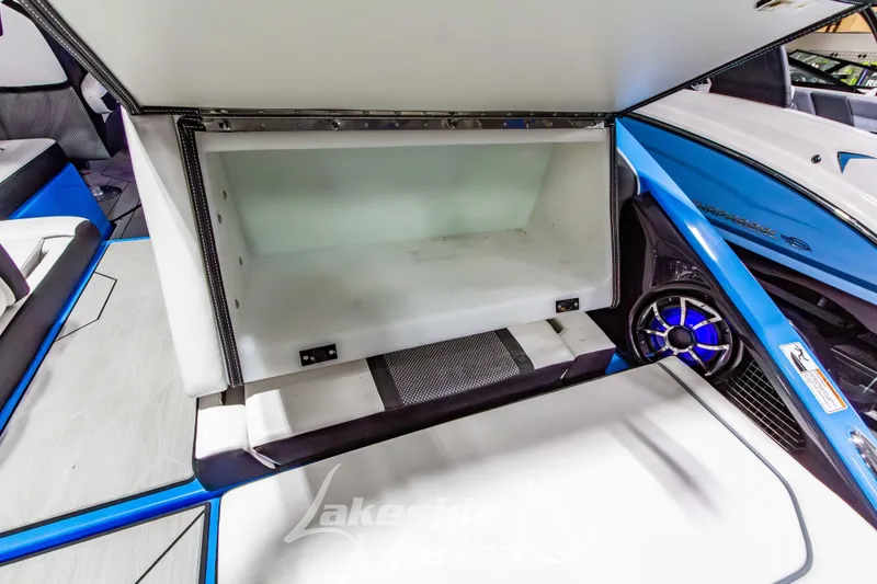 Slide: The Image of 2023 Yamaha Boats 255XE storage compartment with blue accents and speaker detail. - 12