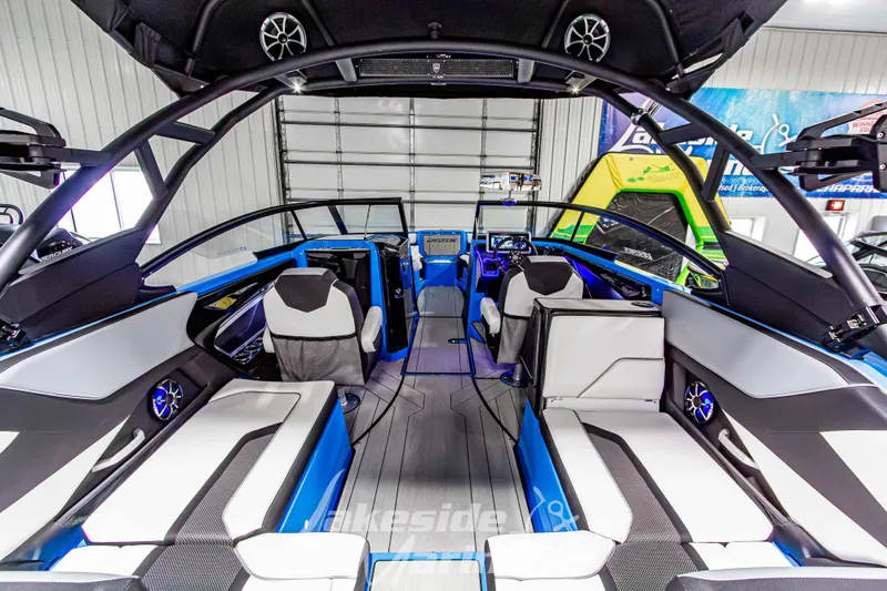 Slide: The Image of 2023 Yamaha Boats 255XE interior with modern seating and advanced dashboard in a showroom. - 17