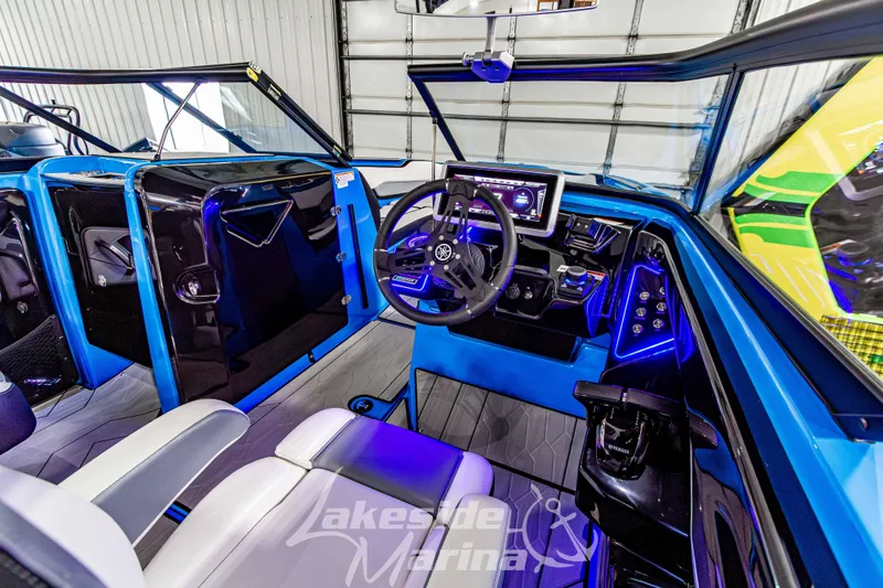 Slide: The Image of 2023 Yamaha Boats 255XE interior with modern dashboard and blue LED lighting. - 29