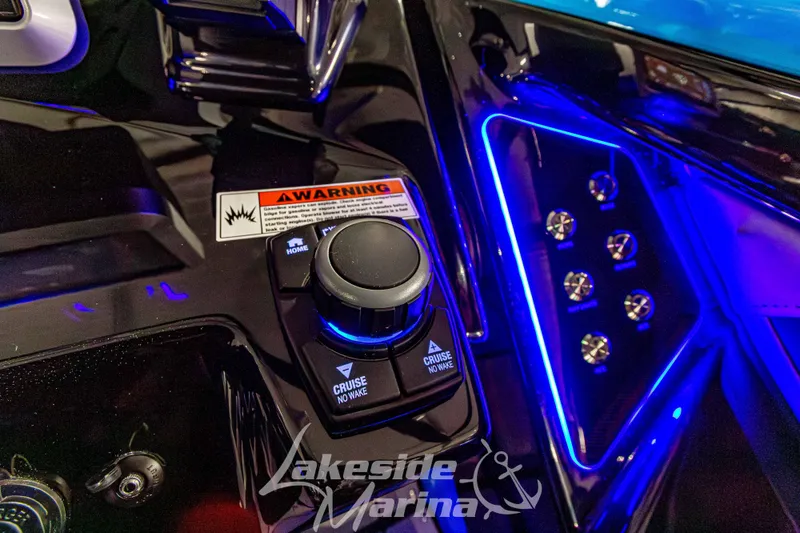 Slide: The Image of Control panel of 2023 Yamaha Boats 255XE with illuminated buttons and warning label. - 36