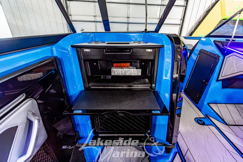 Slide: The Image of 2023 Yamaha Boats 255XE interior with open storage compartment, blue and black design. - 39