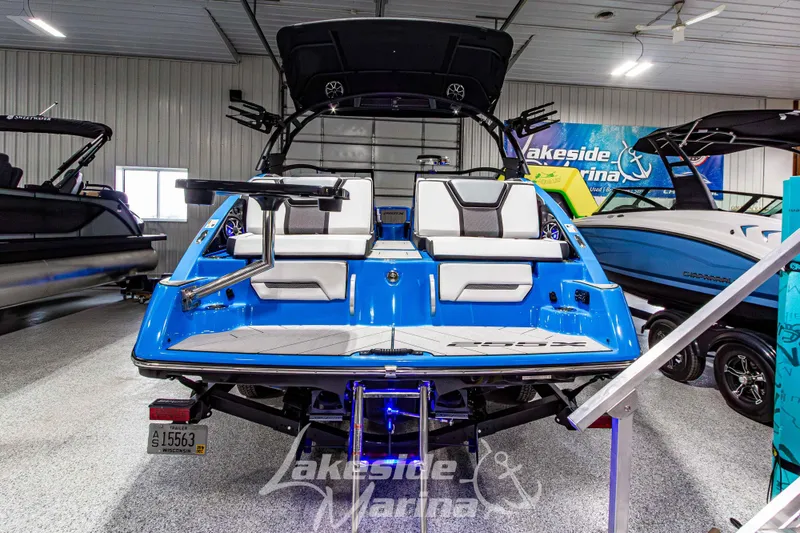 Slide: The Image of 2023 Yamaha Boats 255XE in showroom, vibrant blue exterior, sleek design, Lakeside Marina display. - 4