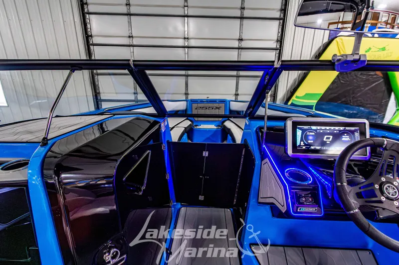Slide: The Image of 2023 Yamaha Boats 255XE interior with modern dashboard and steering wheel in a showroom. - 43