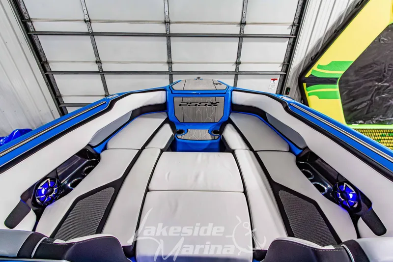Slide: The Image of 2023 Yamaha Boats 255XE interior with sleek seating and modern design in a marina setting. - 48