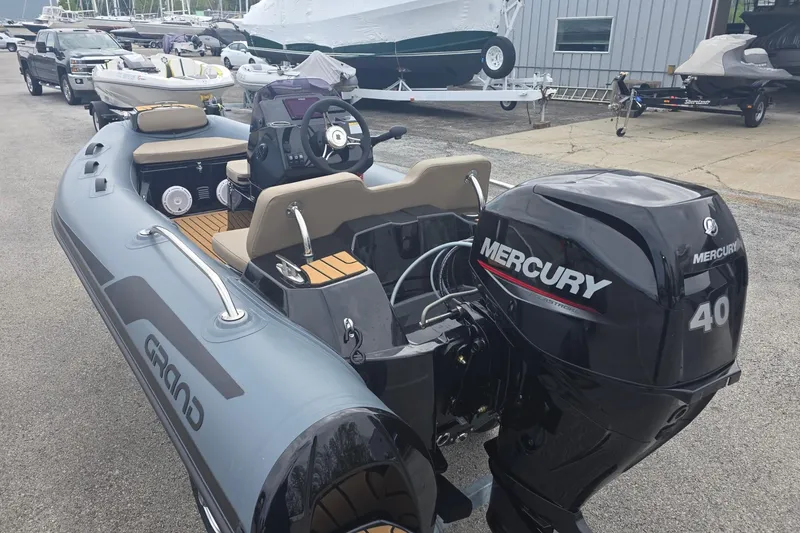 The Image of 2027 Grand Inflatables G380N boat with Mercury 40 engine, parked outdoors. - 0