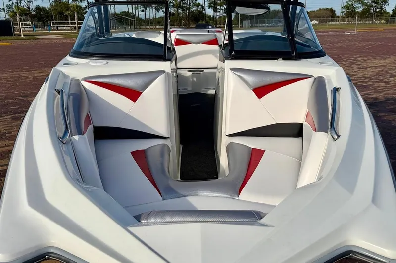 Slide: The Image of 2012 Tigé R20 boat interior with red and white seating, parked on brick pavement. - 5
