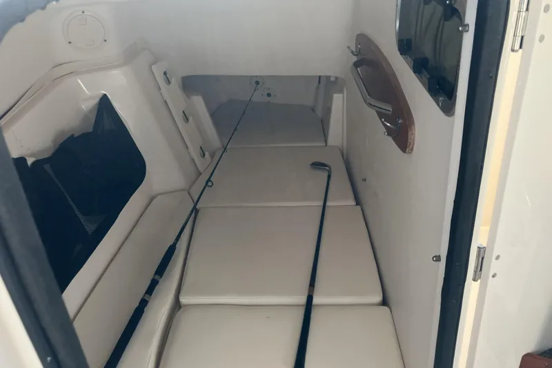 Slide: The Image of 2019 Grady-White Freedom 307 cabin interior with fishing rod and cushioned seating. - 19