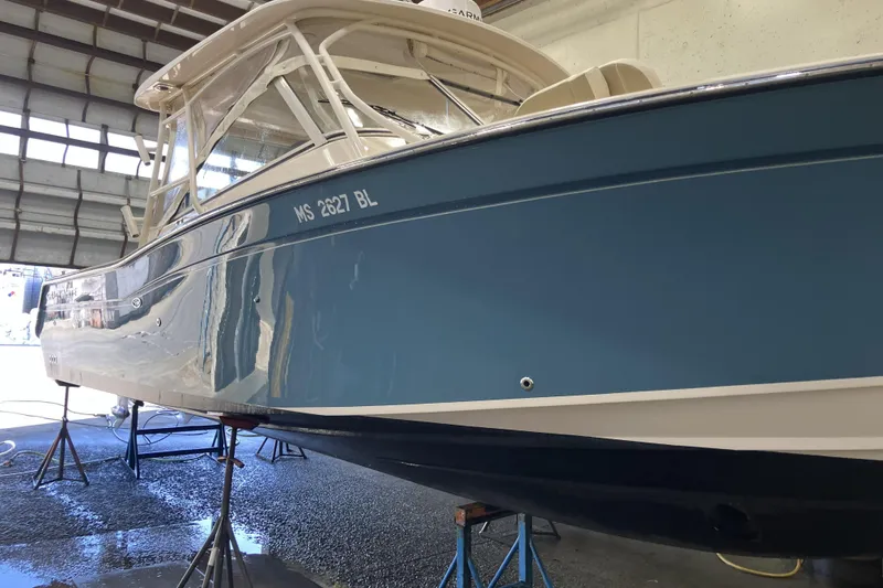 Slide: The Image of 2019 Grady-White Freedom 307 boat in a garage, elevated on stands. - 24