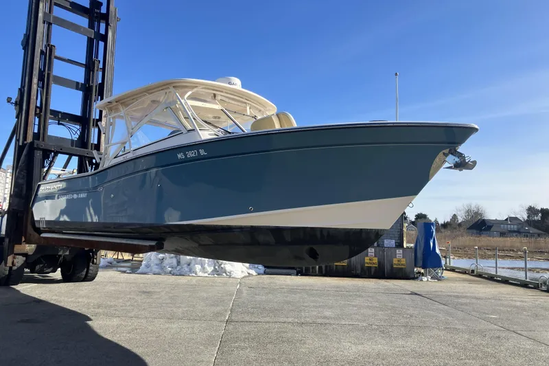 Slide: The Image of 2019 Grady-White Freedom 307 boat on forklift, dockside under clear blue sky. - 4