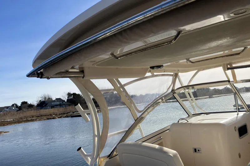 Slide: The Image of 2019 Grady-White Freedom 307 boat interior with clear canopy, overlooking serene waterway. - 8