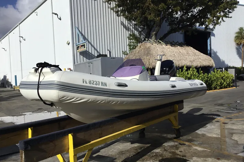 The Image of 2018 Brig E 480 inflatable boat on trailer near industrial building. - 0