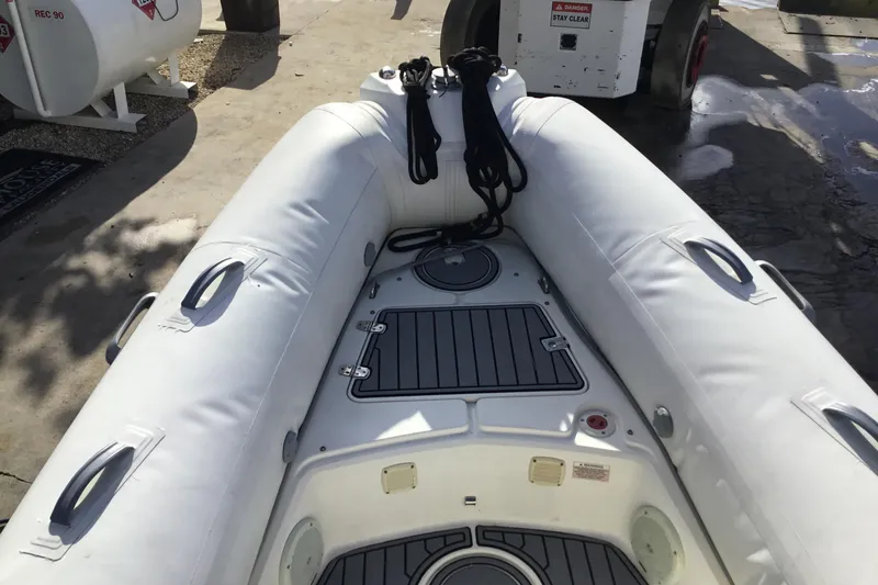 Slide: The Image of 2018 Brig E 480 inflatable boat interior with white seating and storage compartments. - 11