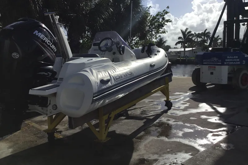 Slide: The Image of 2018 Brig E 480 inflatable boat with Mercury engine on a dockside lift. - 3