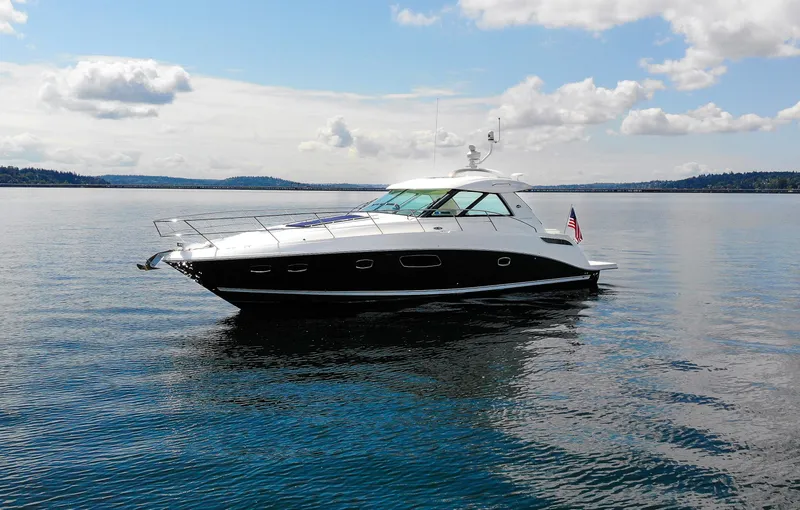 The Image of 2011 Sea Ray 450 Sundancer yacht on calm water under a partly cloudy sky. - 0