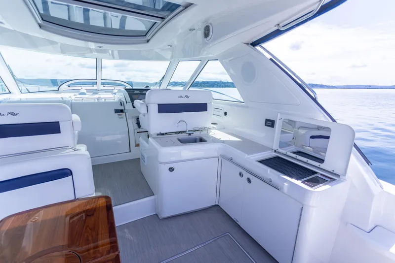 Slide: The Image of Interior of 2011 Sea Ray 450 Sundancer yacht with modern seating and kitchenette. - 12