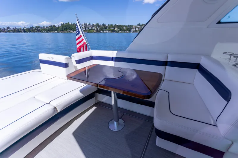 Slide: The Image of Luxurious 2011 Sea Ray 450 Sundancer yacht interior with seating and table, overlooking serene waters. - 17