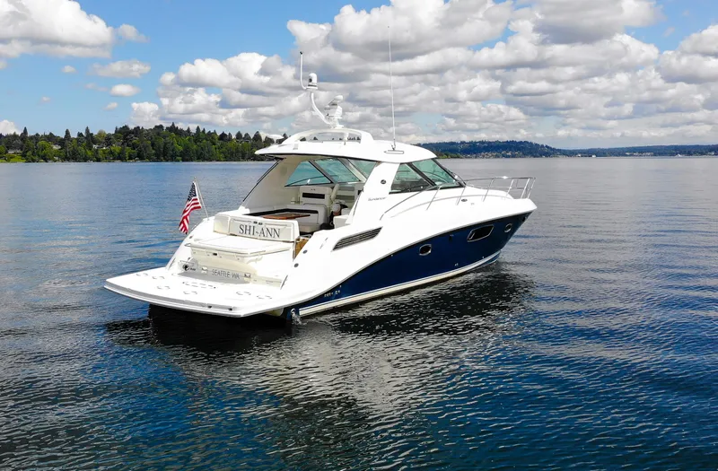 Slide: The Image of 2011 Sea Ray 450 Sundancer yacht on calm water under a partly cloudy sky. - 3