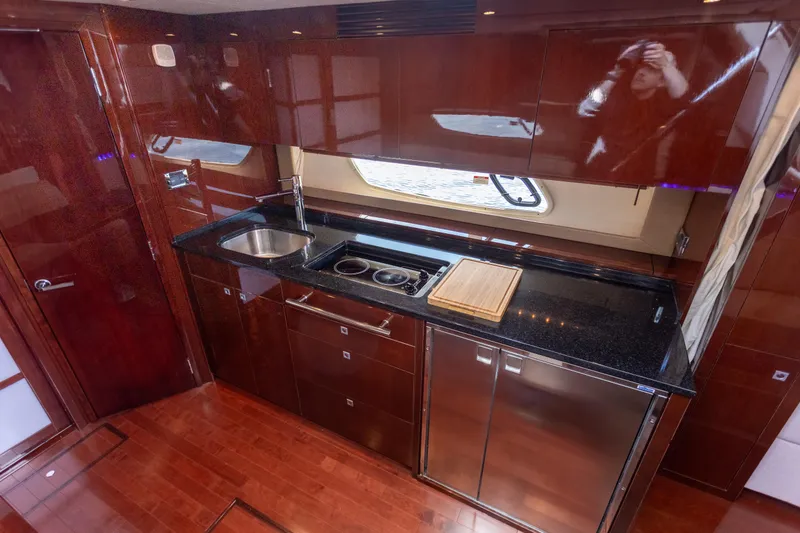 Slide: The Image of Luxurious 2011 Sea Ray 450 Sundancer yacht kitchen with sleek wood cabinetry and modern appliances. - 30
