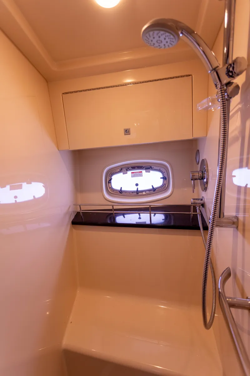 Slide: The Image of 2011 Sea Ray 450 Sundancer shower area with modern fixtures and porthole window. - 43