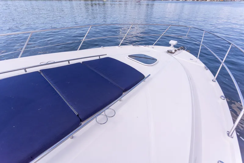 Slide: The Image of 2011 Sea Ray 450 Sundancer yacht deck with blue sun pads on calm water. - 45