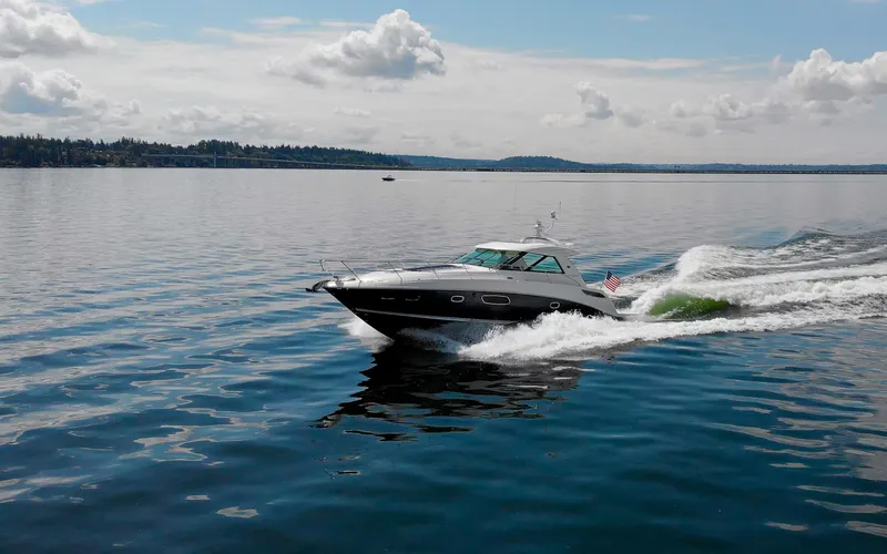 Slide: The Image of 2011 Sea Ray 450 Sundancer cruising on a calm lake under a cloudy sky. - 47