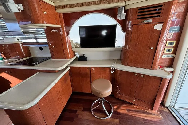 Slide: The Image of Luxurious 1998 Sea Ray 480 Sedan Bridge interior with wood cabinetry and modern amenities. - 26