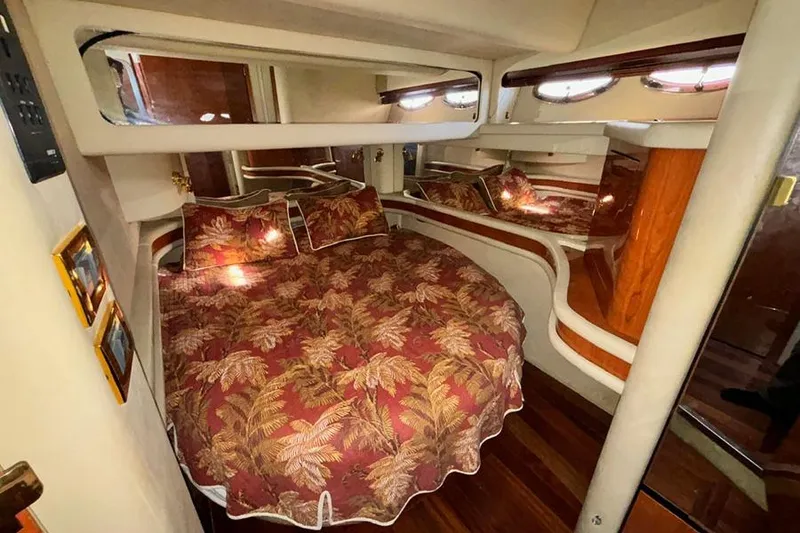 Slide: The Image of Luxurious 1998 Sea Ray 480 Sedan Bridge bedroom with tropical bedding and elegant wood accents. - 29