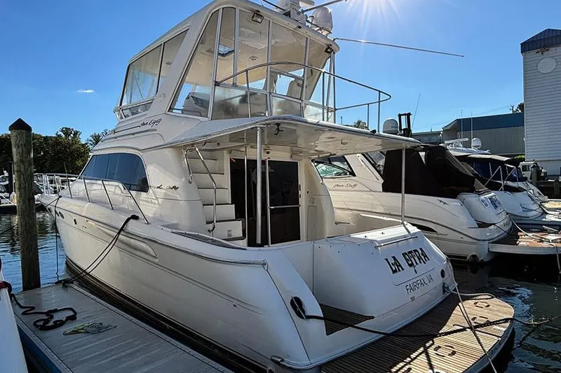 The Image of 1998 Sea Ray 480 Sedan Bridge yacht docked at marina under sunny sky. - 3
