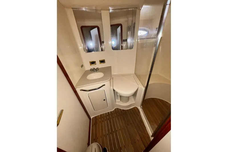 Slide: The Image of Bathroom interior of 1998 Sea Ray 480 Sedan Bridge yacht, featuring sink and shower. - 30