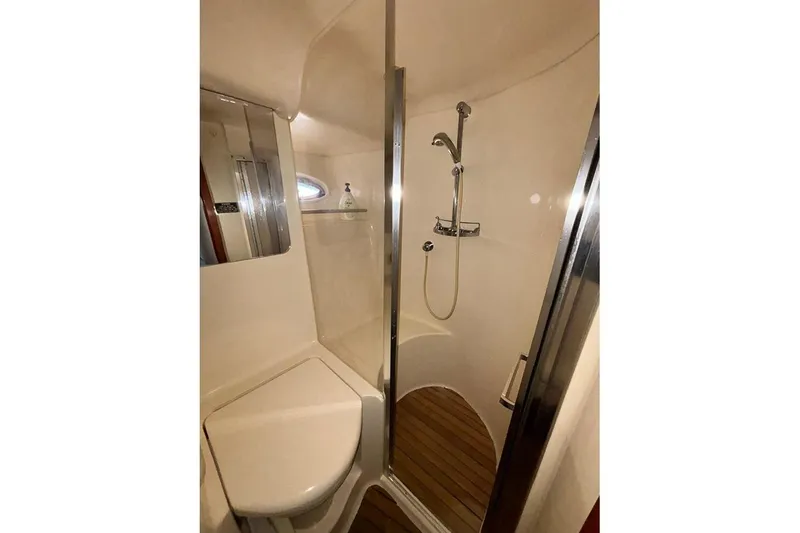 Slide: The Image of 1998 Sea Ray 480 Sedan Bridge bathroom with shower, mirror, and wooden floor. - 31