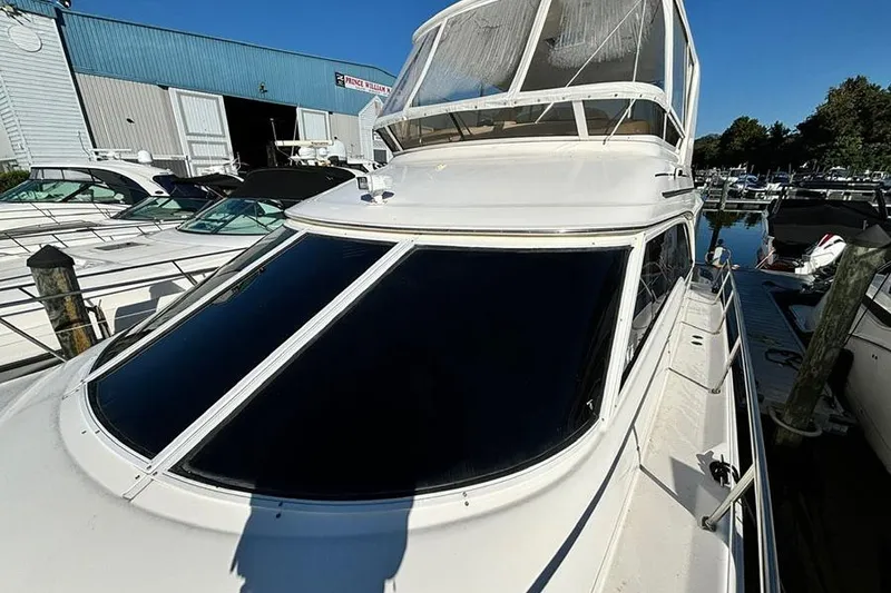 Slide: The Image of 1998 Sea Ray 480 Sedan Bridge yacht docked at marina under clear blue sky. - 41